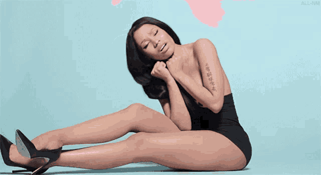a woman with a tattoo on her arm is laying on the ground