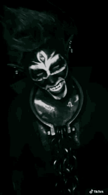 a black and white photo of a person with face paint and a collar