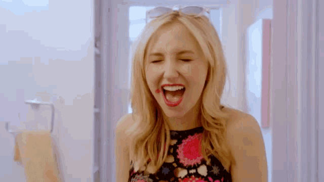 a woman with red lipstick on her lips is wearing sunglasses and making a funny face