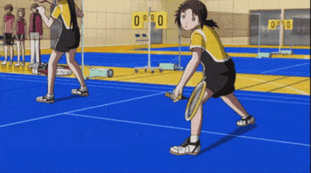 two girls are playing badminton on a court with a scoreboard behind them that says 0-90