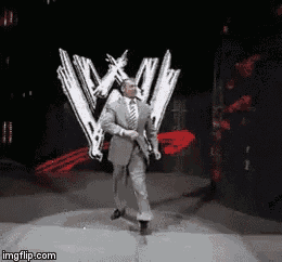 a man in a suit and tie is walking on a stage in front of a w logo .
