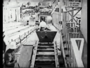 a black and white photo of a roller coaster with a letter y in the background