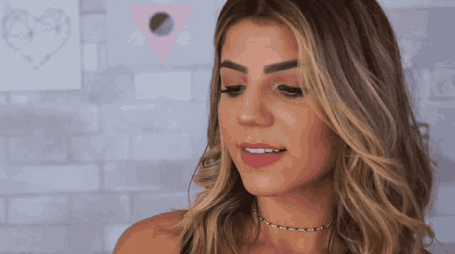 a close up of a woman 's face against a brick wall