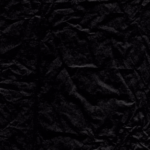 a crumpled piece of black paper with a cross in the middle