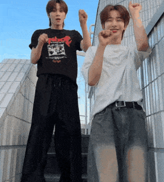 a man wearing a black t-shirt that says the beatles is standing next to another man