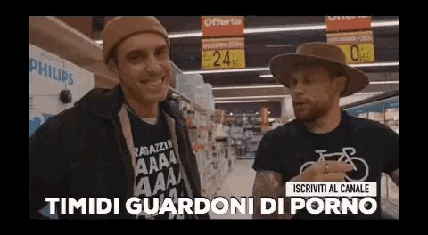 two men are standing in a grocery store and one of them is wearing a shirt that says " timidi guardoni di porno "