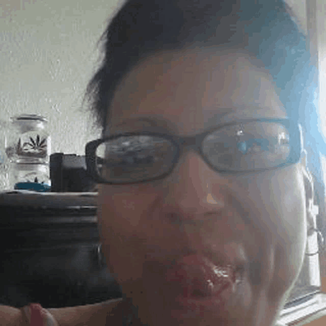 a close up of a woman wearing glasses and making a face .