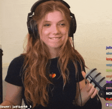 a girl wearing headphones holds a rode microphone