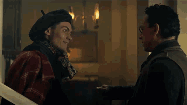 two men are standing next to each other and one has a beret on