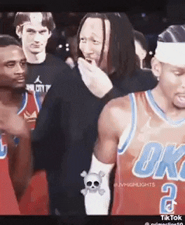 a basketball player wearing a oklahoma city jersey talks to another player