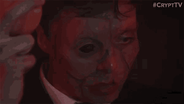 a man in a suit and tie with a mask on his face .