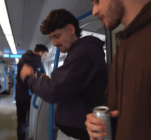 a man with a mustache is holding a can of soda