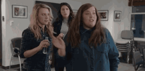 a group of women are standing next to each other in a living room .