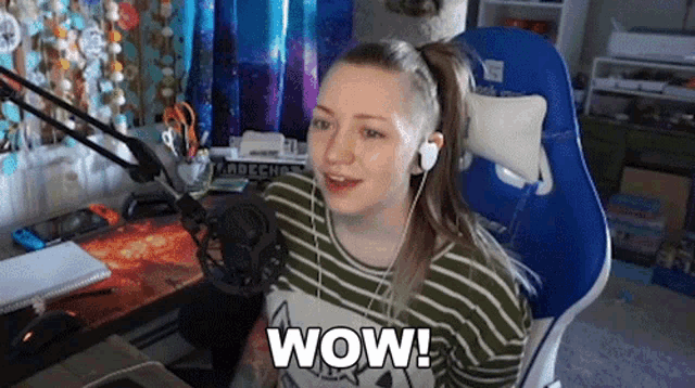 a woman is sitting in front of a microphone with the word wow on her shirt