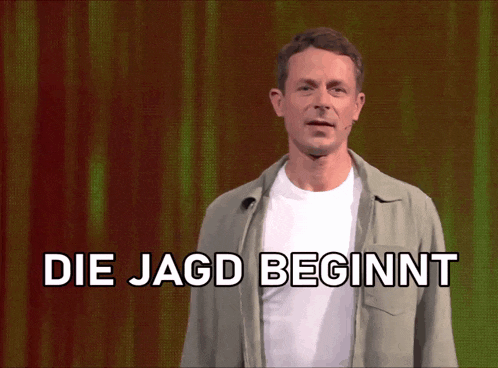 a man stands in front of a screen that says die jagd beginnt