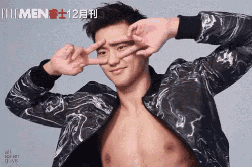 a shirtless man making a peace sign with his hands in front of his face
