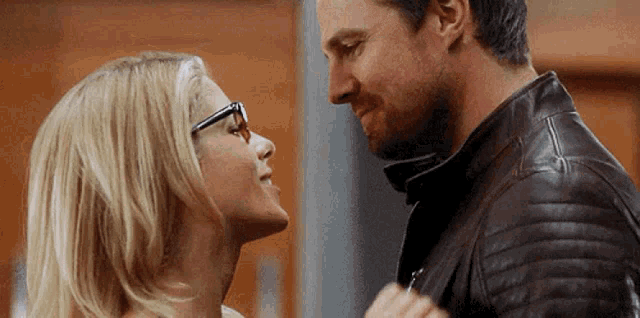 a man and a woman are looking at each other in a room .