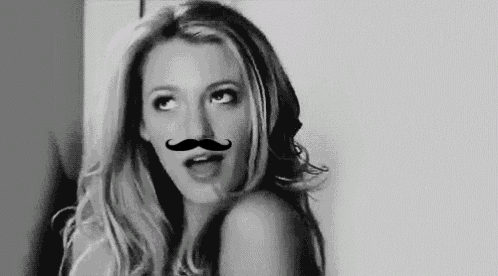 a woman is wearing a fake mustache on her face in a black and white photo .