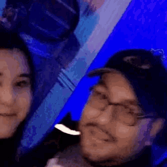a man and a woman are taking a selfie in a dark room .