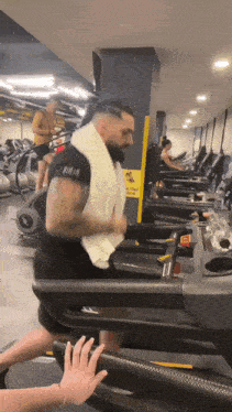 a man is running on a treadmill in a gym .