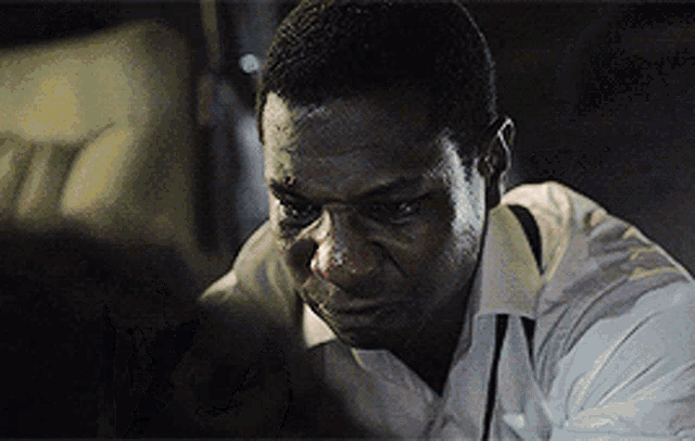 a man in a white shirt has a black spot on his face