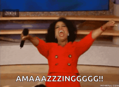 a woman in a red dress is holding a microphone with her arms in the air and says amaaazzzingggg !