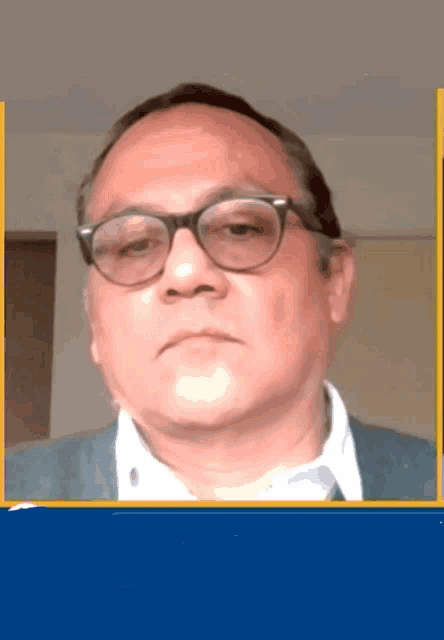 a close up of a man wearing glasses and a blue jacket