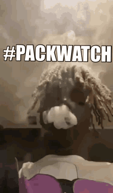 a man with dreadlocks is smoking a cigarette with the words #packwatch above him