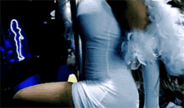 a woman in a blue dress with white feathers on her wings
