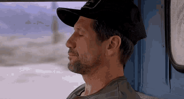 a man with his eyes closed wearing a trucker hat that says national parks