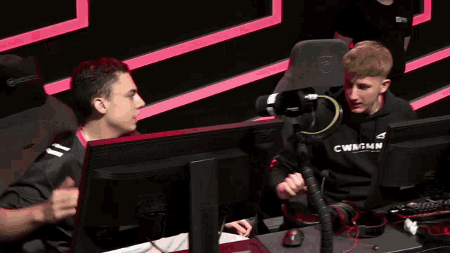 a man in a cwngmn hoodie shakes hands with another man