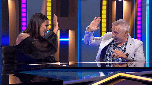 a man and a woman giving each other a high five