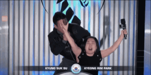 a man is holding a microphone while a woman screams in front of a sign that says kyung suk su