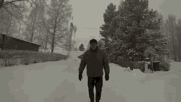 a man is walking down a snow covered street