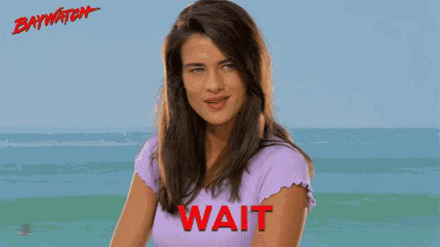 a woman in a purple shirt with the word wait written on it