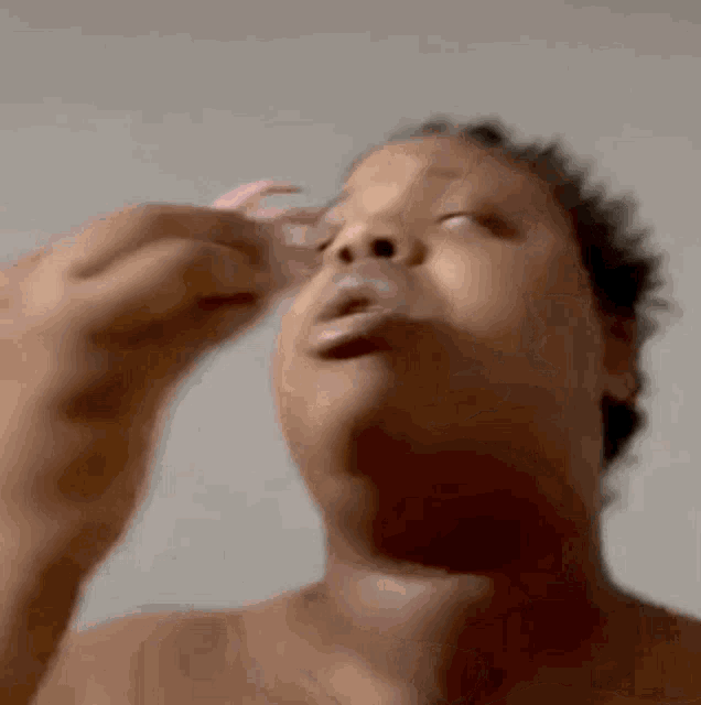 a close up of a person holding a pink object in front of their face .