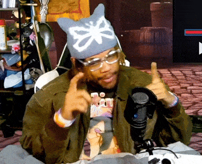 a man wearing a cat hat and glasses giving a thumbs up