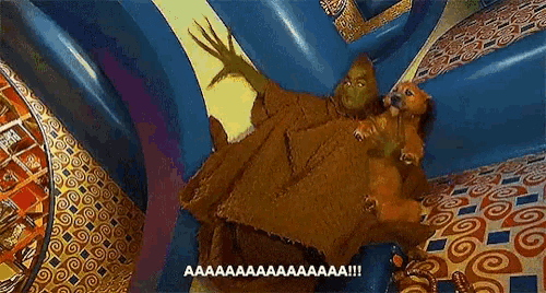 the grinch is holding a dog and screaming while laying on the floor .