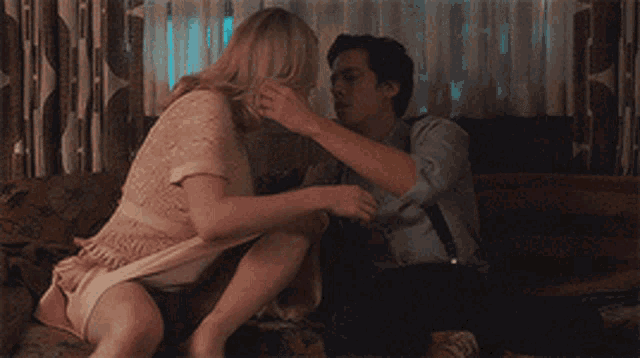 a woman in a pink dress is hugging a man in a white shirt