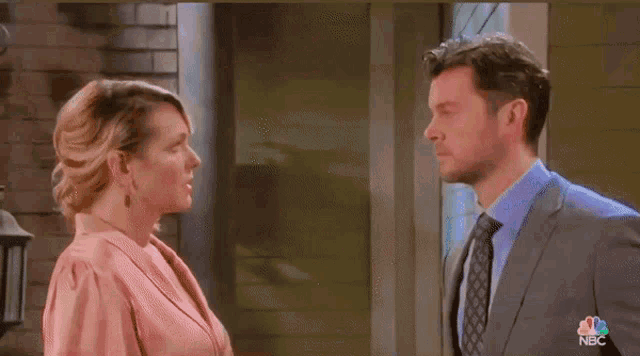 a man in a suit and tie kisses a woman on the forehead