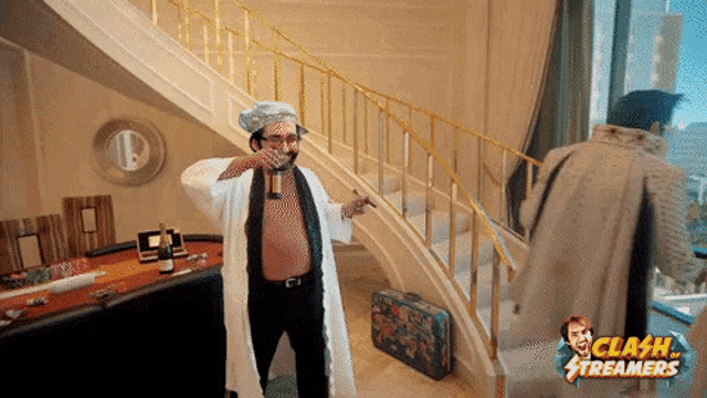 a man in a bathrobe holds a bottle of champagne in front of a staircase with clash streamers in the corner