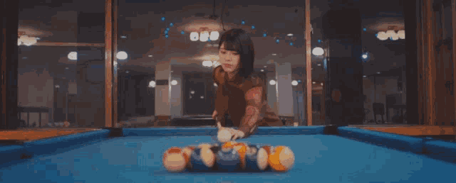 a woman is playing pool on a pool table with balls that have the letter p on them