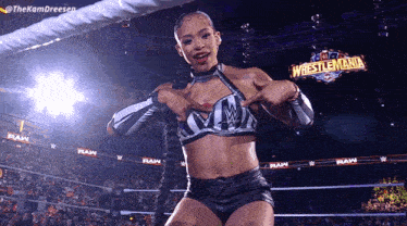 a woman in a wrestling ring with a sign that says wrestlemania