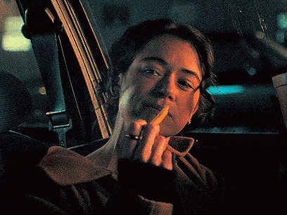 a woman sitting in a car holding a piece of paper