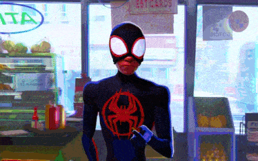 a man in a spiderman costume is standing in front of a sign that says postcards