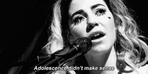 a woman is singing into a microphone in a black and white photo with the words `` adolescence did n't make sense '' .