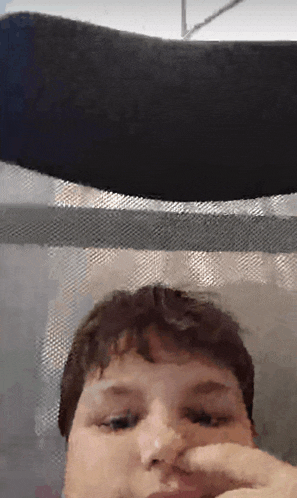 a close up of a person 's face with a black object behind them