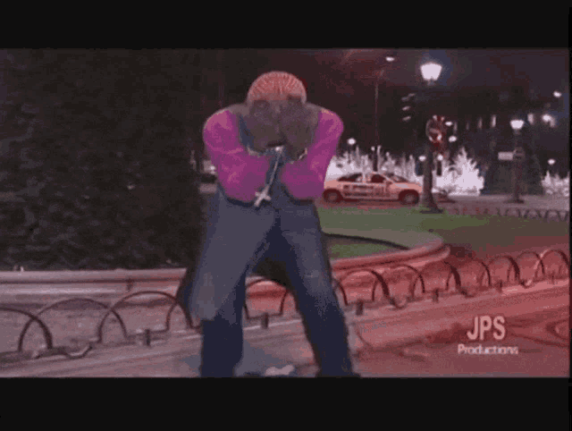 a man standing in front of a fence with jps productions on the bottom