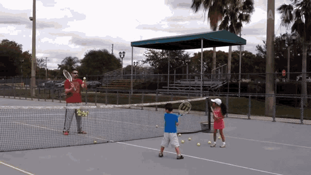 a man and a girl are playing tennis on a court