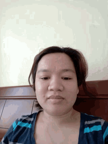 a woman in a blue and white striped shirt smiles